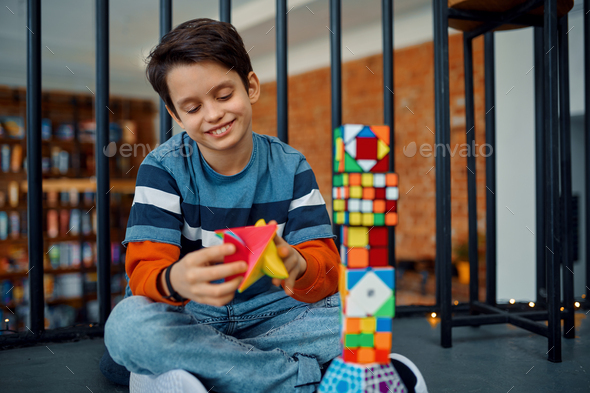 Happy little boy play with puzzle cubes