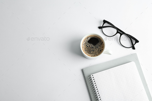 Copybooks, cup of coffee and glasses on white background, space for text