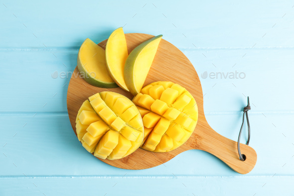 Cutting board with cut ripe mangoes on color background, top view Stock  Photo by AtlasComposer