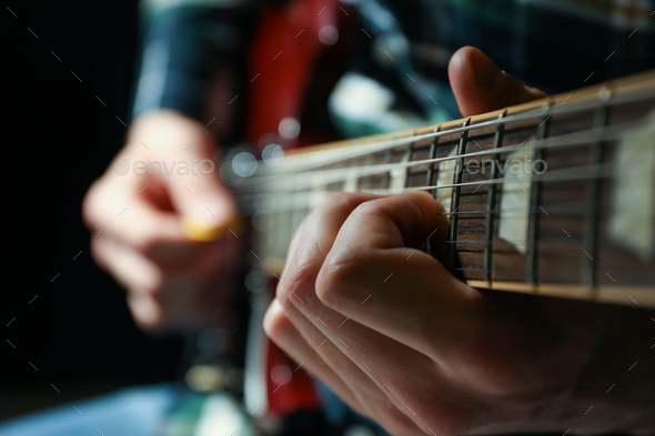 Man Playing On Electric Guitar Against Dark Background Closeup Stock Photo By Atlascomposer