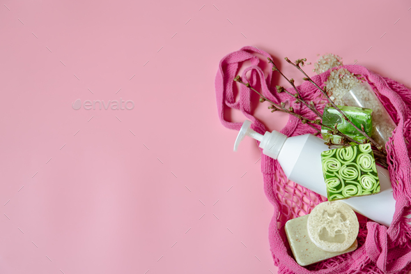 Spa composition with bath accessories in a pink string bag, flat lay. Stock  Photo by puhimec