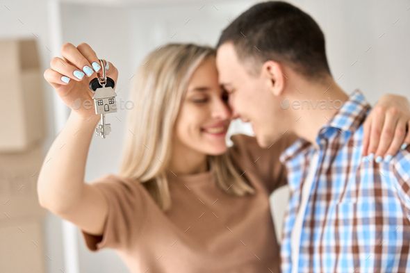 Happy young couple first time home owners holding keys in new home, closeup. - Stock Photo - Images