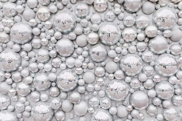 Photo of wall with sparkle elements. Shot of big and little disco balls.