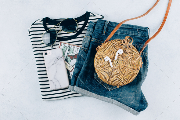 Flat lay with summer women's clothing and accessories. Striped t-shirt,  denim shorts, rattan bag Stock Photo by Anikona