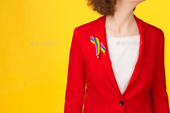 homosexual and lgbt concept - close up of woman wearing gay pride awareness ribbon on her chest - Stock Photo - Images