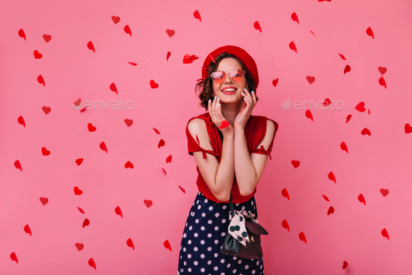 blissful-cute-girl-in-french-attire-looking-at-heart-confetti-shy