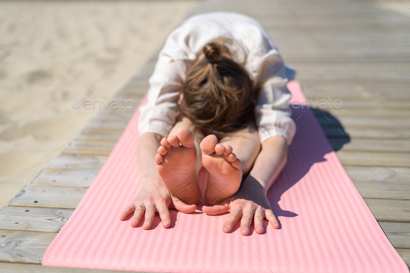 Woman doing yoga poses on beach