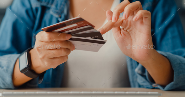 Young asia lady using computer order online shopping product and paying bill with credit card.