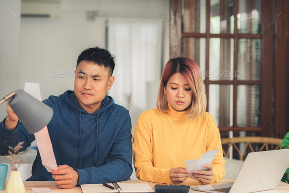 Young stressed asian couple managing finances.