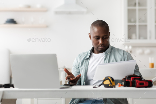 Problems with instructions. Puzzled black handyman reading manual and does not understand what to do