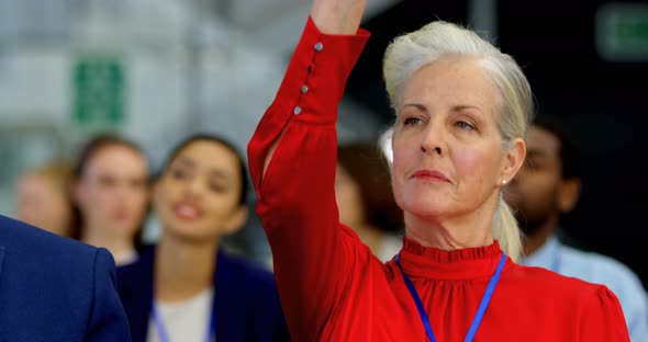 Caucasian businesswoman raising her hand in the business seminar 4k alt