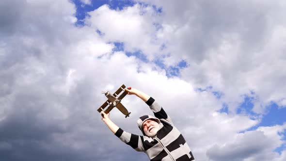 Happy Elderly Man Pretend Flying on Model Aircraft in Sky Traveling