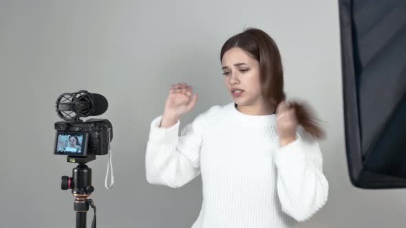 Caucasian Girl Blogger Speaks in Front of Camera Straightens Her Hair Gestures alt
