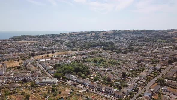 Aerial view of Brixham town in England. Sky view of homes and streets. alt