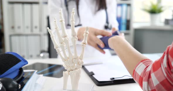 Orthopedic Doctor Bandages Elastic Bandage for Fracture of Patient Arm alt