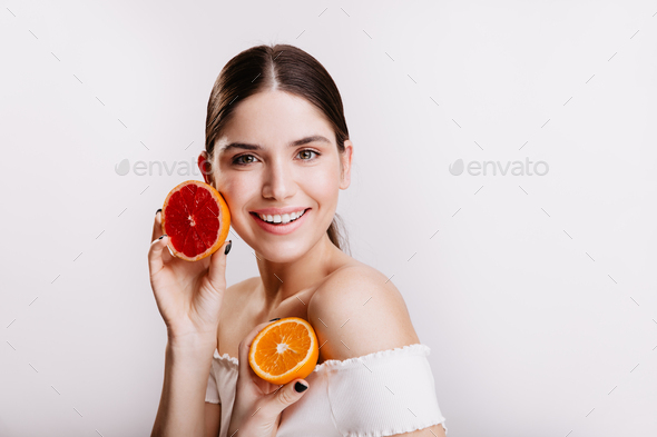 Lady with green eyes in white top posing on isolated background without filters and makeup. Woman h