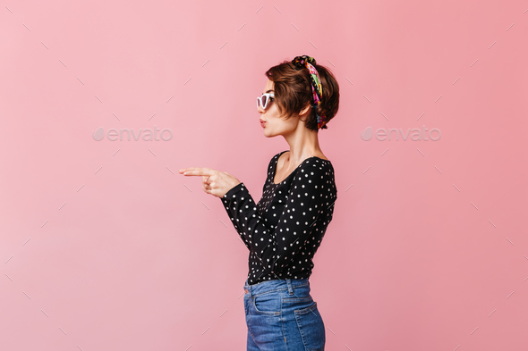 Side view of elegant caucasian woman with short haircut. Trendy slim girl isolated on pink backgrou