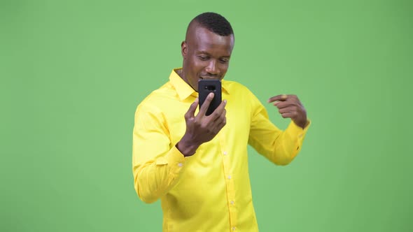 Young Happy African Businessman Video Calling and Showing Phone alt