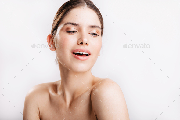 Sensual dark blond lady without make-up poses for portrait without filters on white background