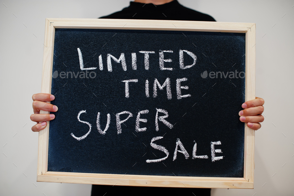 Limited time super sale written on blackboard. Black friday concept. Boy hold board.