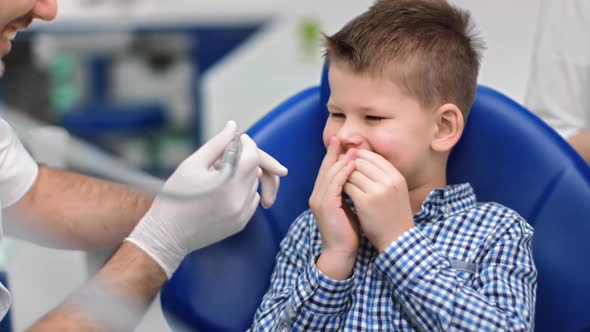 Smiling Boy Closed Mouth Fear Drilling Machine at Stomatology alt