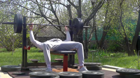 Man Athlete Trains in the Garden During Quarantine on Selfisolation alt