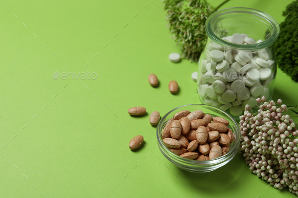 Concept of herbal medicine pills on green background, space for text Stock  Photo by AtlasComposer