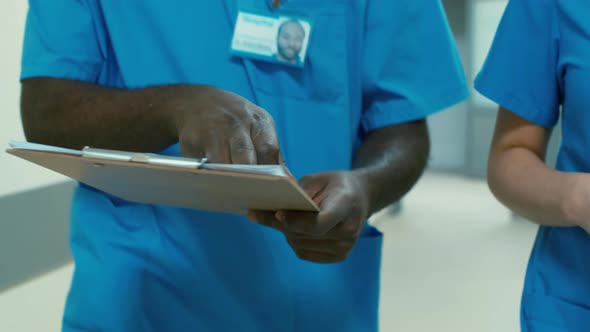 Multiethnic medical stuff walking through hospital hall during break