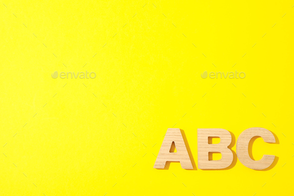 Wooden letters of English alphabet on color background, space for text  Stock Photo by AtlasComposer