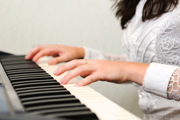 Hands play musical composition on piano