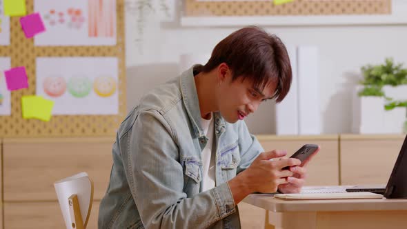 Relaxed Asian man using smart phone surfing internet, update  social media, texting message. Techie alt