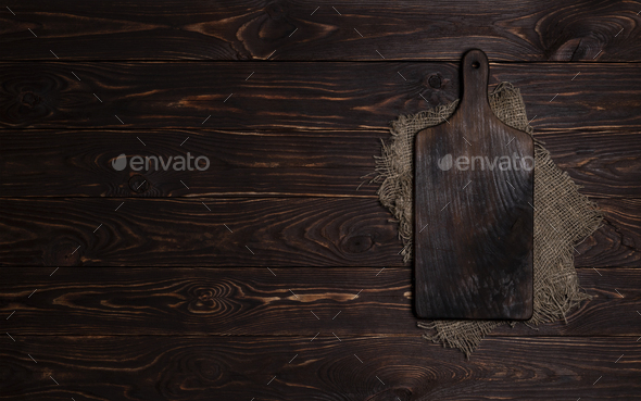 Cutting Board On Dark Wood Background Top View Stock Photo