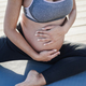 Pregnant woman doing yoga meditation on the beach - Maternity and