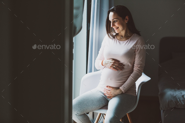 Pregnant woman sitting on a chair Stock Photo