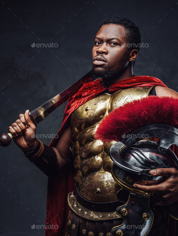 Proud roman warrior of african descent holding gladius on his shoulder