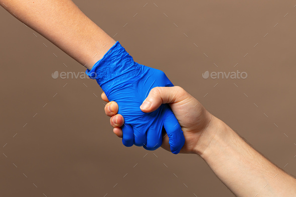Handshake in a blue gloves, help concept. Personal hygiene during a pandemic