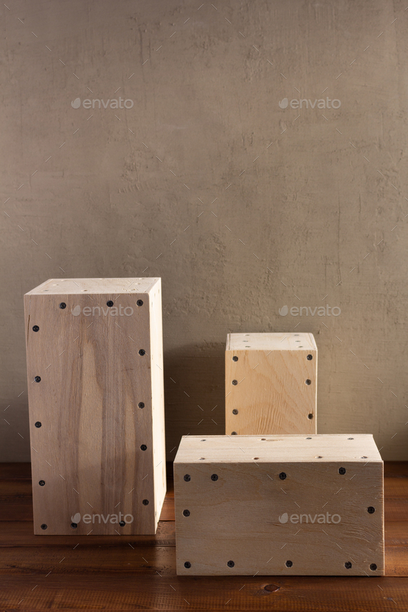 Wooden cube or plywood box block near wall background texture. Abstract construction concept