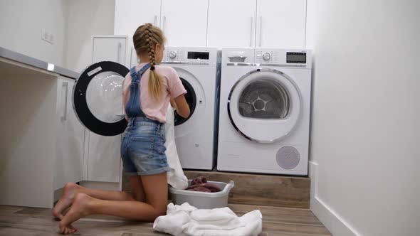 Teenage Daughter Doing Housework in Laundry and Put Dirty Laundry in the Washing Machine