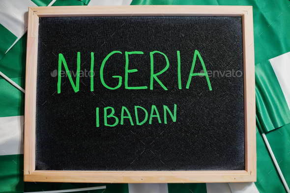 Happy independence day of Nigeria, Ibadan. Text on board with nigerian flags. - Stock Photo - Images