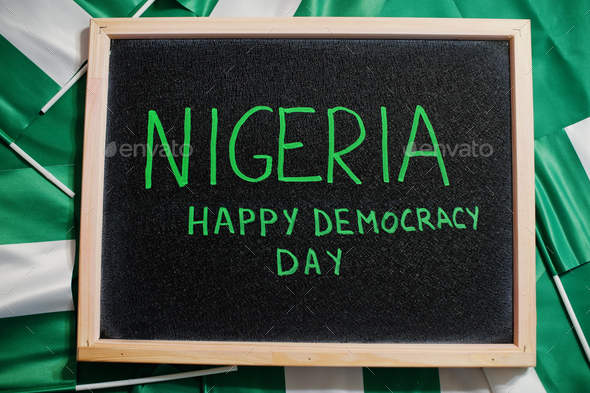 Happy democracy day of Nigeria. Text on board with nigerian flags. - Stock Photo - Images