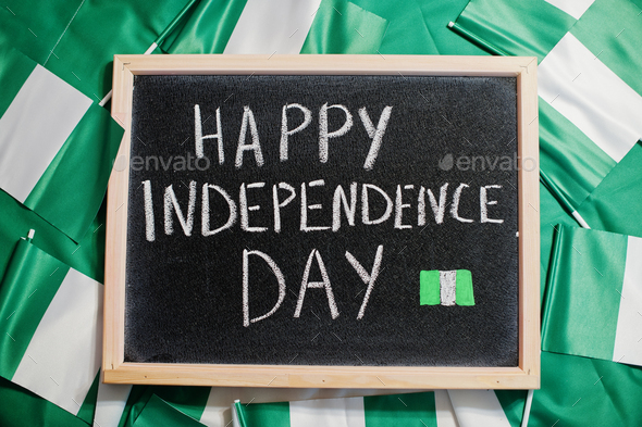 Happy independence day of Nigeria. Text on board with nigerian flags. - Stock Photo - Images