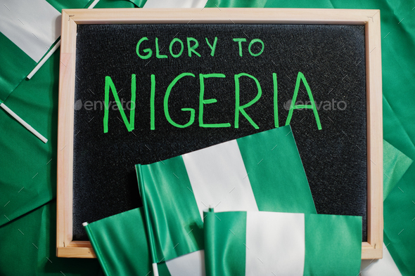 Glory to Nigeria. Text on board with nigerian flags. - Stock Photo - Images