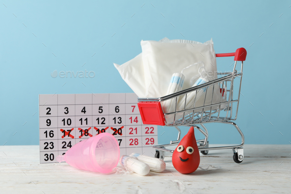 Shop trolley with menstruation period accessories on wood table, close up