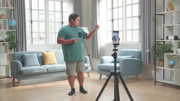 Man Blogger Shoots Video Content For Social Networks By Smartphone Camera, Magician With Red Ball alt