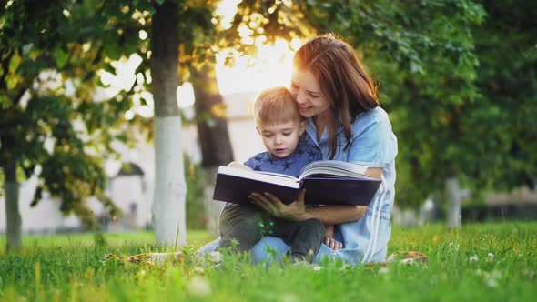 Lovely Mother Reads a Book To Her Little Son alt