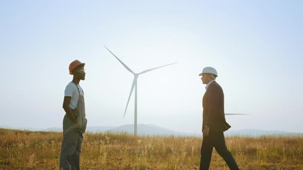 African American Man in White Helmet and Black Suit Shaking Hands with Indian alt
