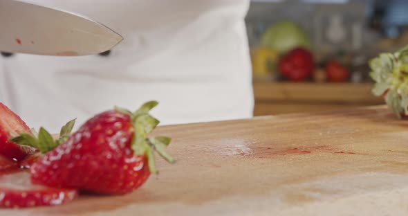 Close up of a chef knife slicing a Strawberry alt
