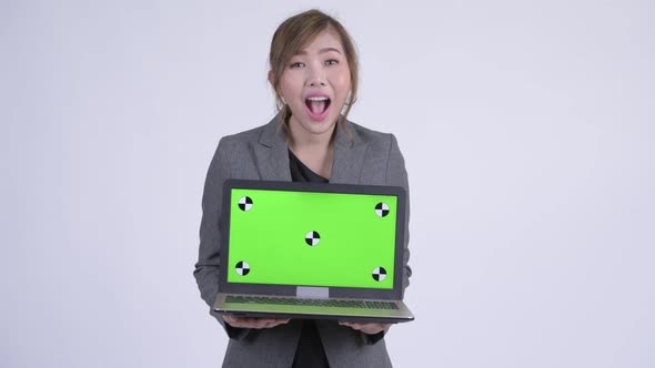 Young Happy Asian Businesswoman Showing Laptop and Looking Surprised alt