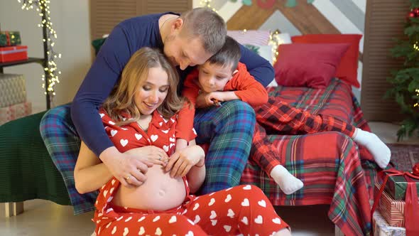 Beautiful Happy Family in Pajamas in the New Year's Bedroom alt