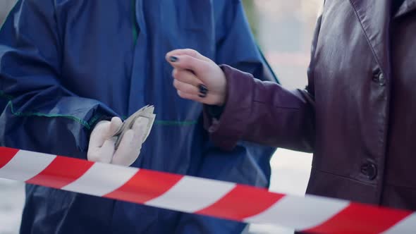 Unrecognizable Caucasian Woman Paying Criminalist Outdoors on Sunny Winter Day alt